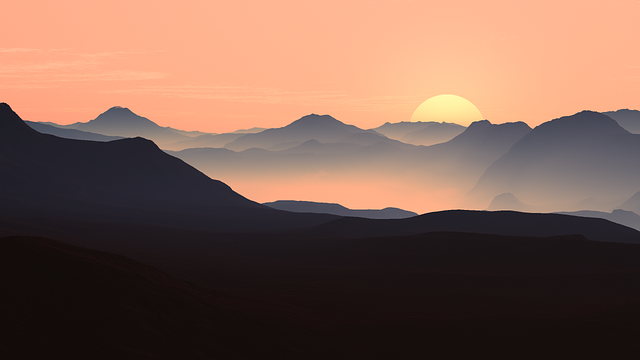 Paysage de montagnes en couches au soleil levant ou couchant. Premiers plans sombres, dégradé de bleu-gris brumeux et ciel orangé.